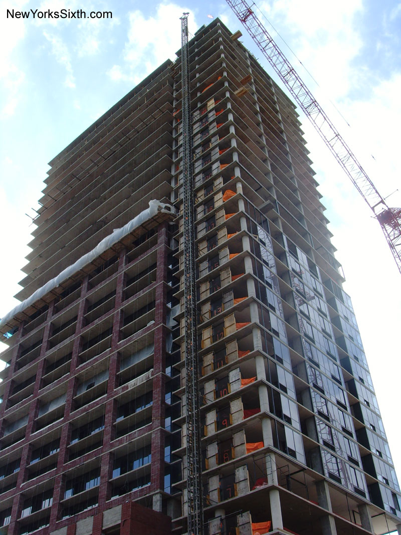 A crane lifts materials to the top of the Athena Tower in Jersey City